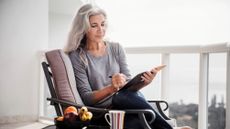 Mature woman sitting on chair on balcony 