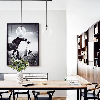 dining area with white wall and frame on wall with flower vase