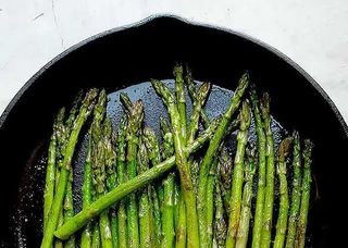 stalks of asparagus cooked in a cast-iron skillet