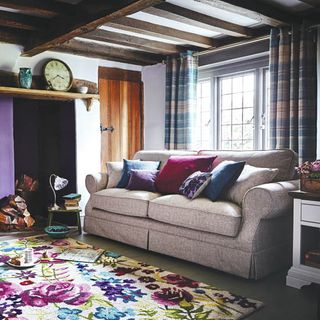 living room with sofa and floral carpet