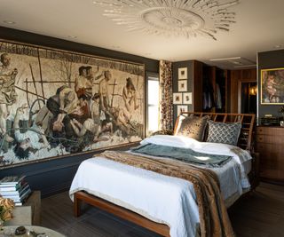 Bedroom with dark walls and large paintings