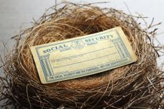 A social security card rests in a birds nest conveying the concept of social security income being considered an intregal part of ones financial nest egg.