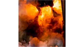 flames erupt from the base of a spacex rocket during an engine test
