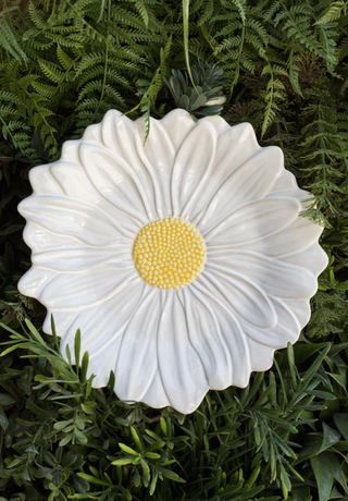 textured daisy plate on top of grass