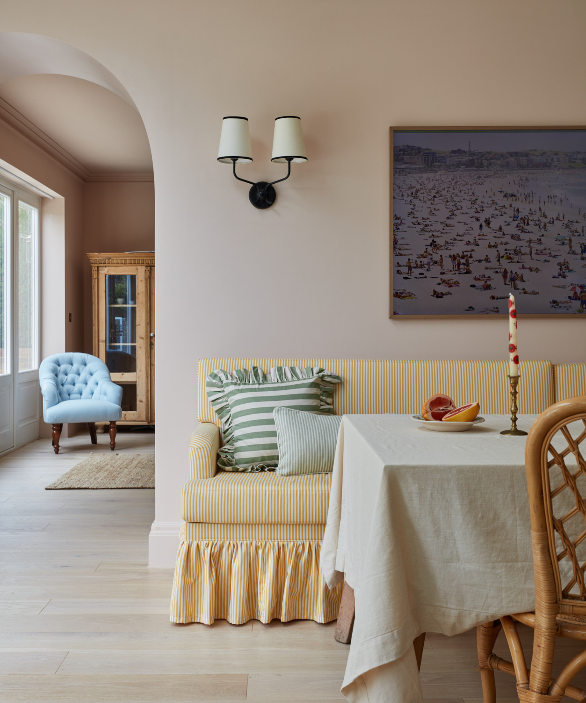 dining area with yellow stripe dining bench and pink walls