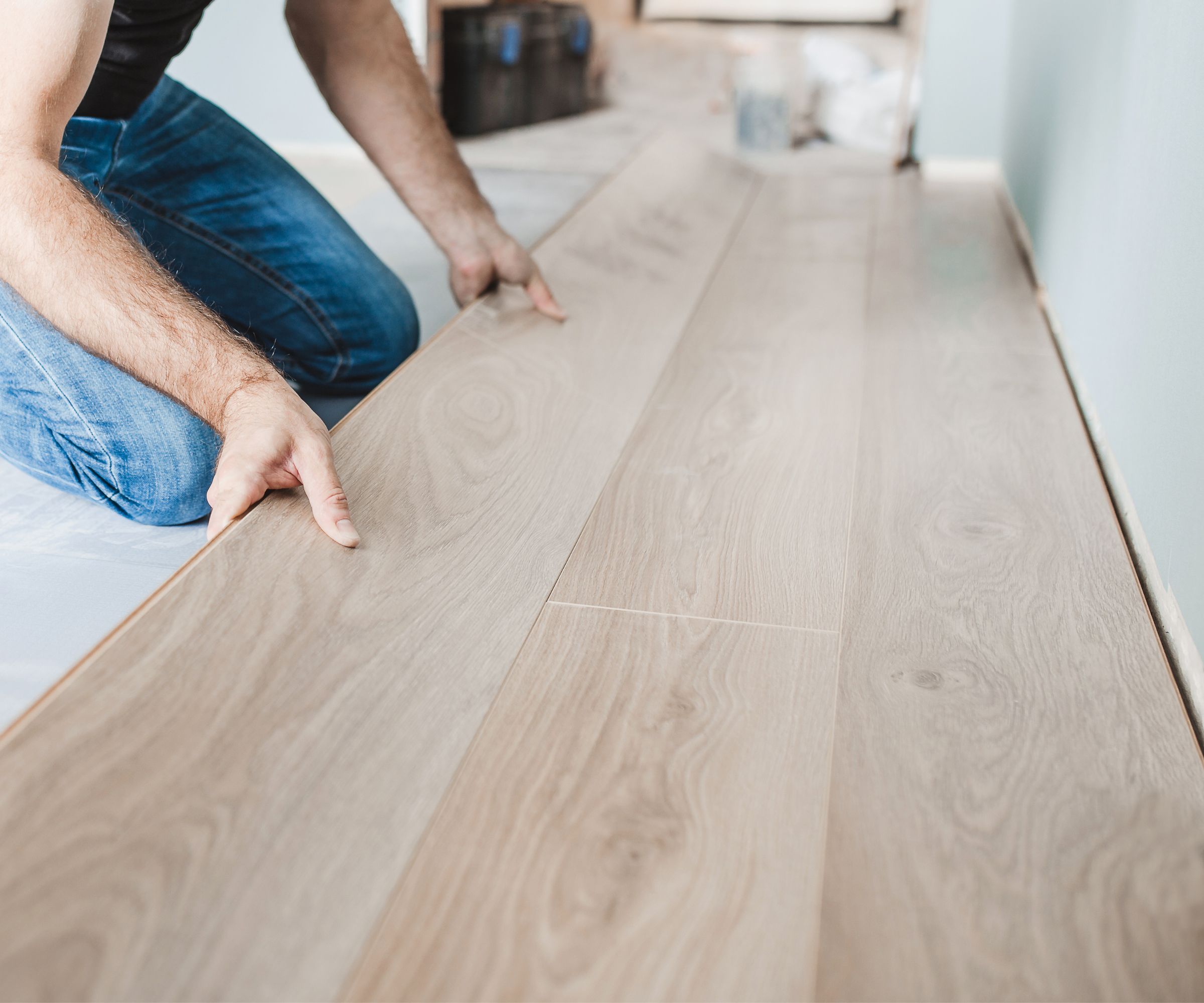 Close-up of the work of a master floating flooring installation - installing laminate on the floor