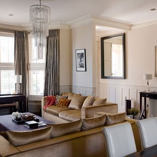 living area with brown sofa and cushions and white wall
