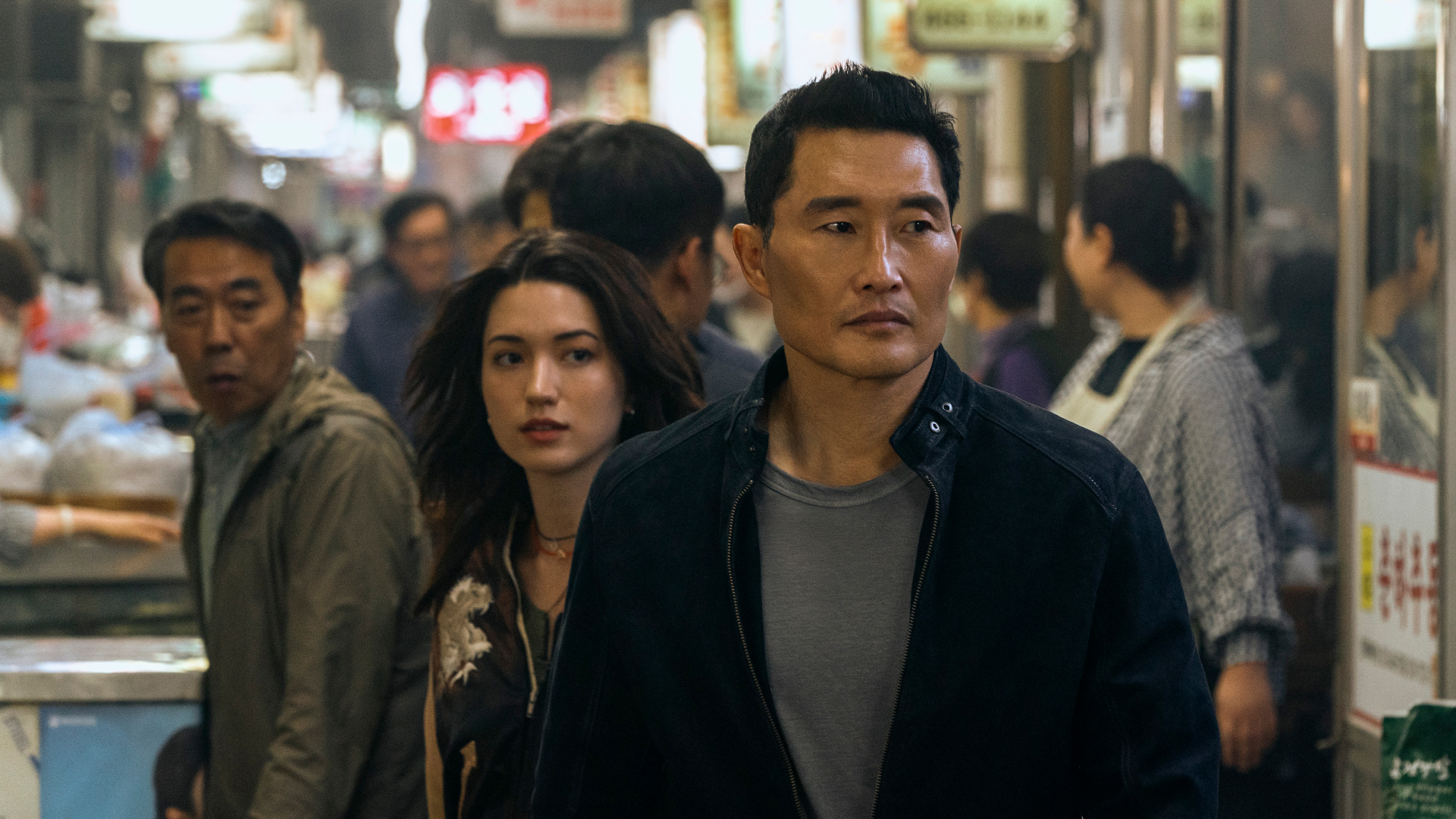 Two people (Reina Hardesty and Daniel Dae Kim, center) walk through a crowded Korean night market, in &#039;Butterfly.&#039;
