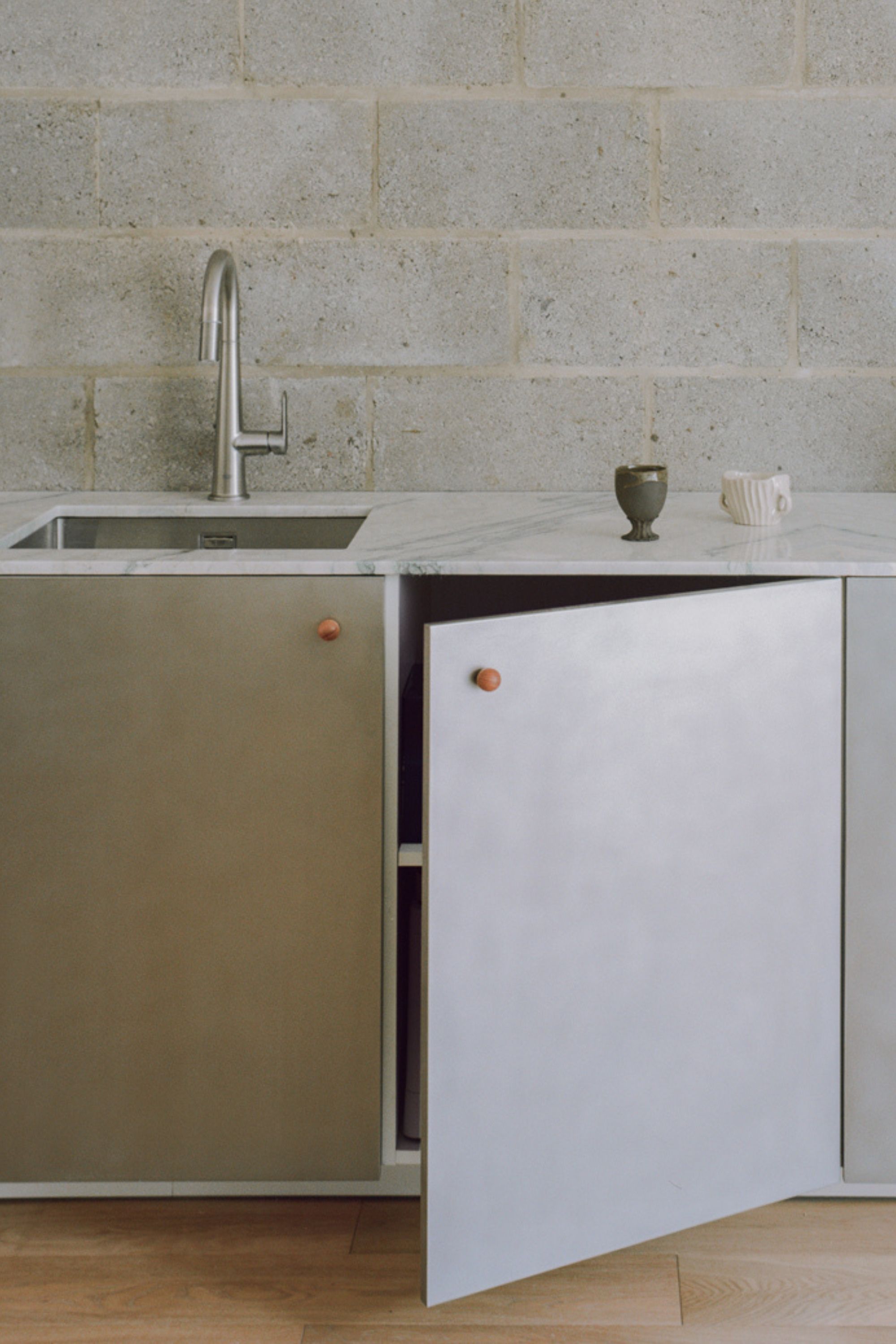 a brushed stainless steel kitchen against a breezeblock wall