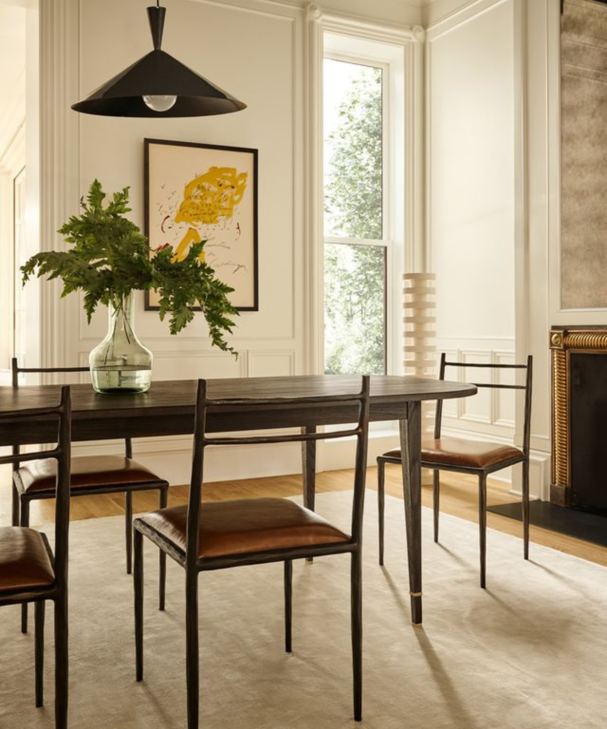 a dining room with a dark wood table, several dining chairs, and a light tan rug