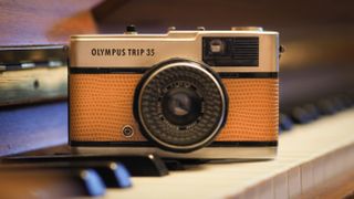 An Olympus Trip 35 sitting on the keys of a piano