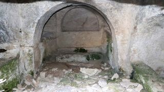 One of the rock-cut chamber tombs, with the sarcophagus carved into the floor.