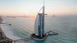 External drone shot of Jumeirah Burj Al Arab at sunset