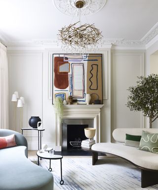 Modern fireplace with abstract art above mantelpiece and curved sofas