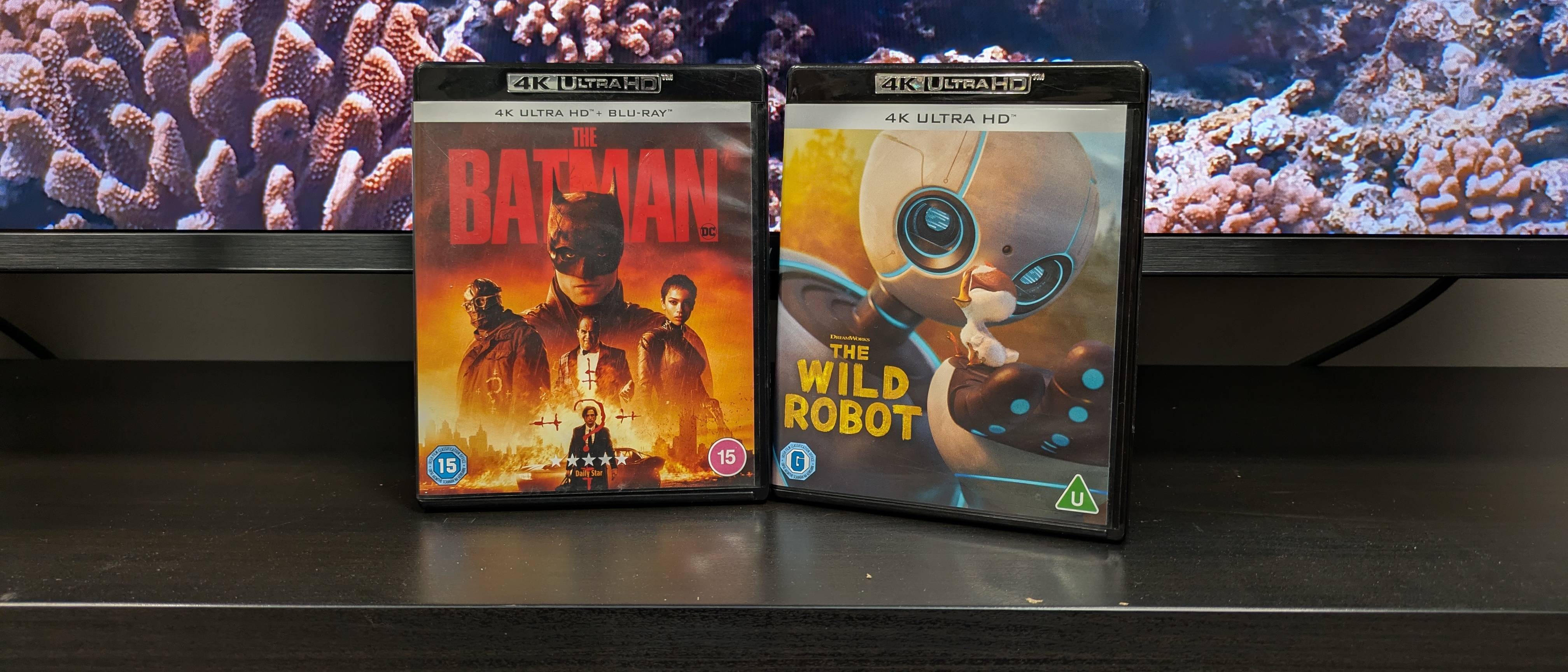 4K Blu-ray collections hero image with The Batman and The Wild Robot 4K Blu-ray cases in front of a TV 