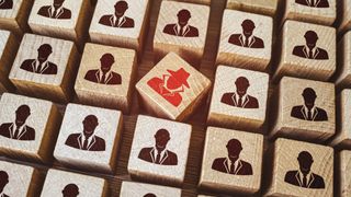 Red insider threat painted on Wooden cube surrounded by others with employee icons 