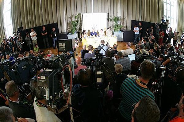 The assembled media questions Rasmussen over his failure