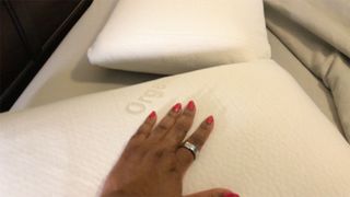 A hand on a Brooklyn Bedding Talalay Latex Pillow