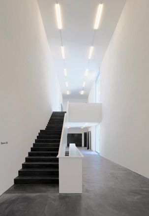 Black staircase and grey floor in an otherwise white space