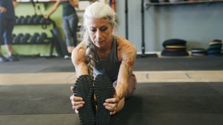 Fit middle-aged women strething in a CrossFit gym
