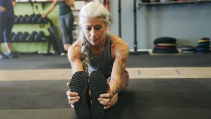 Mature woman stretching in the gym