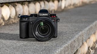 Panasonic Lumix S5D mirrorless camera on a set of stone steps with sunlight hitting the camera from the side creating shadows