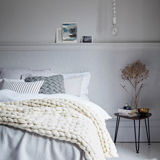 bedroom with white wall and white bed with pillows