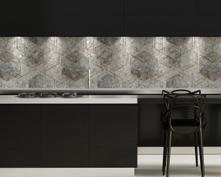 A black kitchen with grey geometric wallpapered backsplash