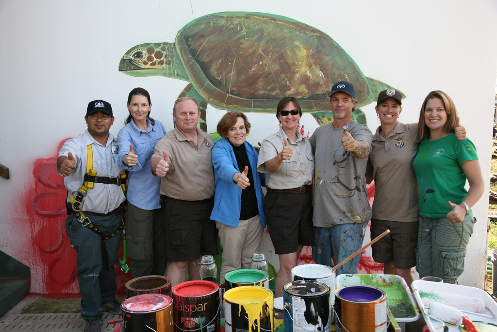 Kriangkrai Sriprasert, Cindy McArthur, Ray Born, Dr. Sylvia Earle, Ann Bell, Wyland, Ann Meyer, and Michelle Jones celebrate the completion of Wyland's view through Midway Atoll National Wildlife Refuge's "window" into Papahanaumokuakea Marine National Monument. Charlie Barracks Wall -- Midway Atoll.