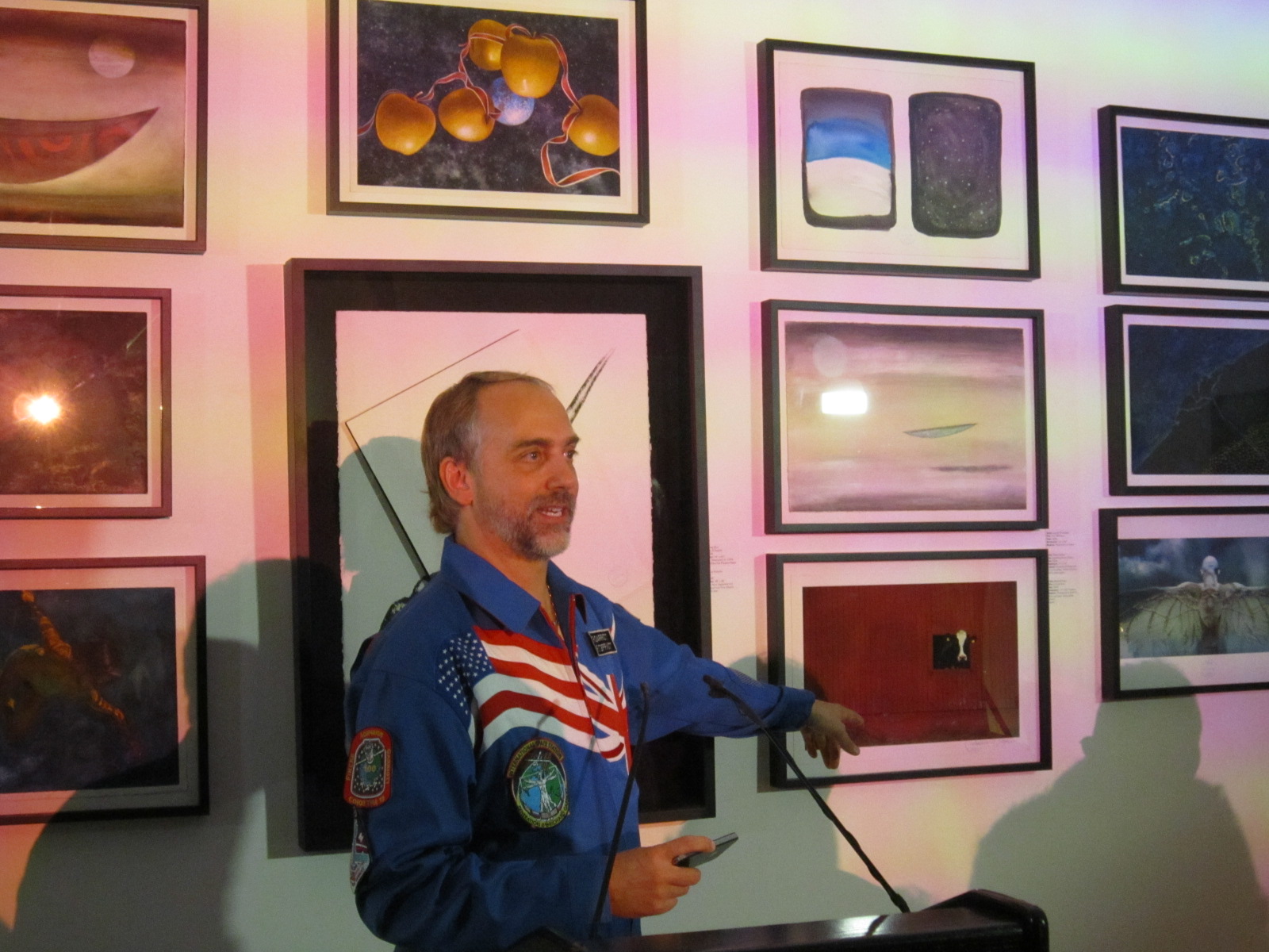 Richard Garriott, an American space tourist and video game developer, stands in front of pieces of art that were displayed on the International Space Station in 2008. The artwork is part of a free exhibit, called Celestial Matters, at the Charles Bank Gal