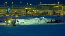 A Delta airlines plane sits on its roof after crashing upon landing at Toronto Pearson Airport in Toronto, Ontario