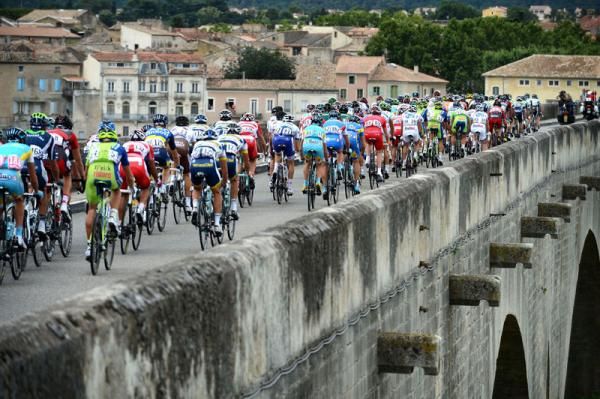 The peloton crosses a bridge on stage 13