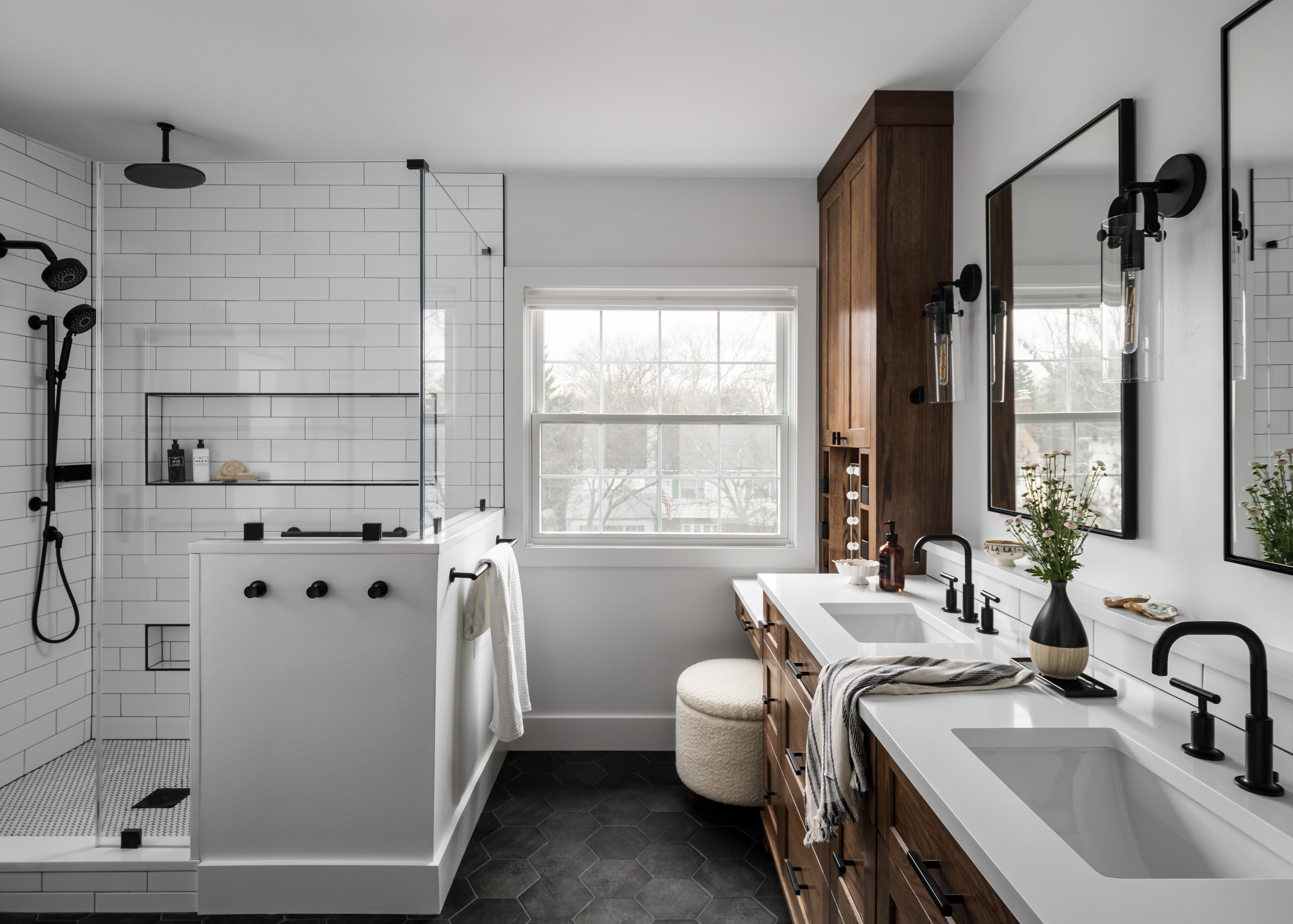a white and black themed spacious modern bathroom with a shower toilet and two sinks side by side