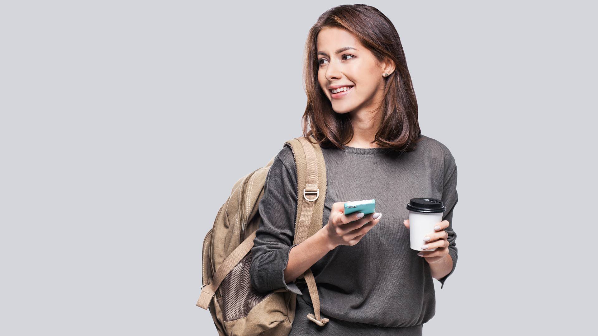 A traveller carries their phone and a coffee
