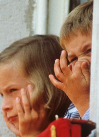 A young Zara Phillips and Prince William caught looking out the windows of Buckingham Palace