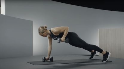 A renegade row demonstrated by a Peloton instructor as part of a dumbbell workout 