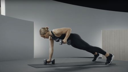 A renegade row demonstrated by a Peloton instructor as part of a dumbbell workout 