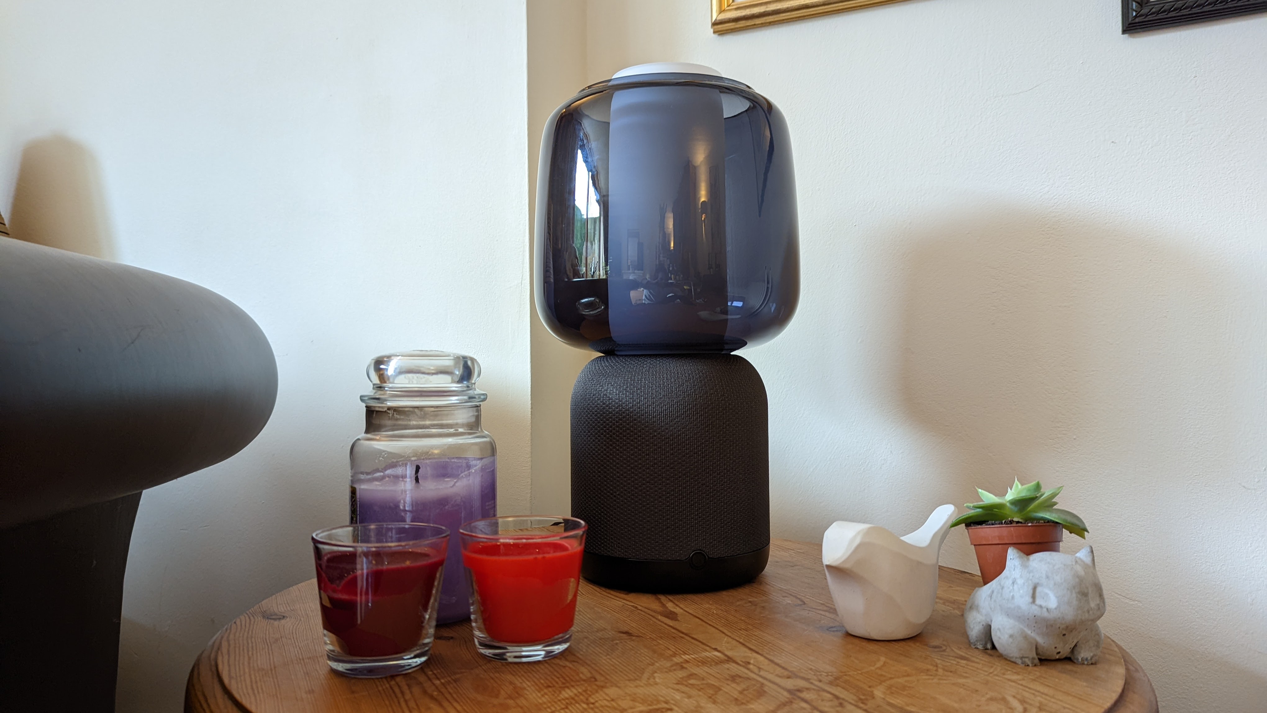 Symfonisk Table Lamp Speaker (Gen 2) on a table with candles and a plant