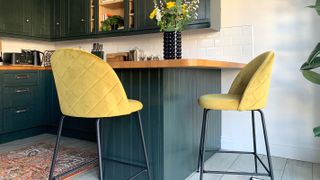 dark blue breakfast bar with yellow kitchen stools