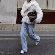 woman in jeans and shaggy fur jacket