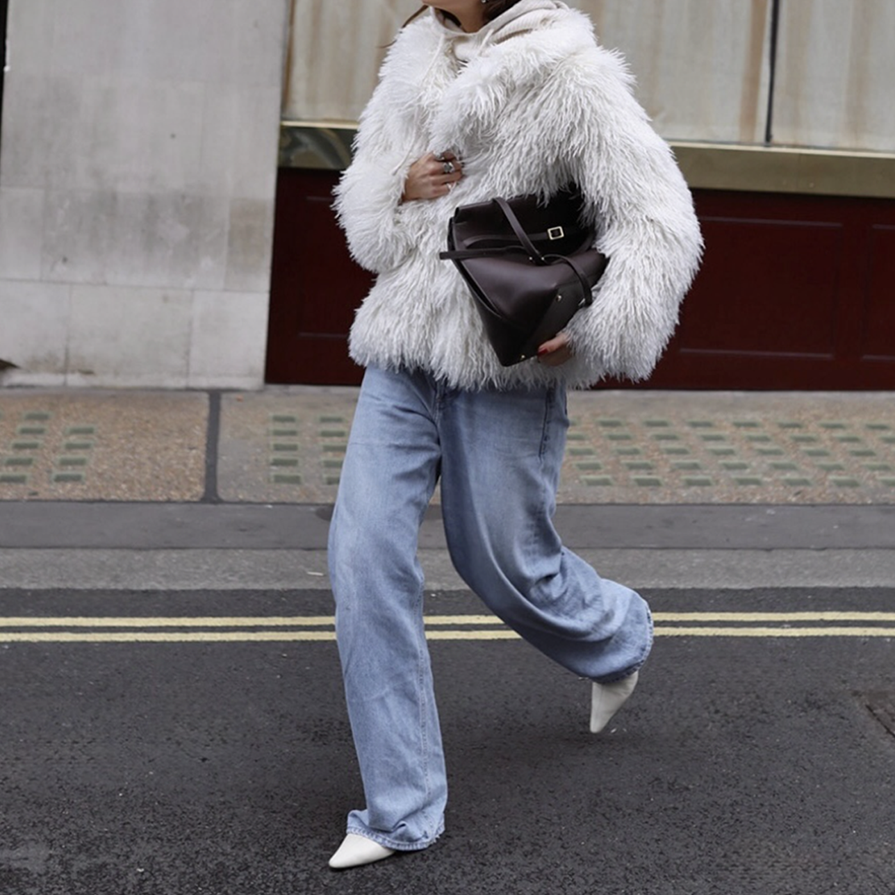 woman in jeans and shaggy fur jacket