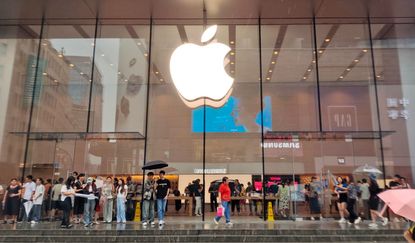 Customers brave the rain to inquire about exchanging their old iPhones for new ones at Apple's flagship Nanjing Road Pedestrian Street store in Shanghai, China, on September 10, 2024.