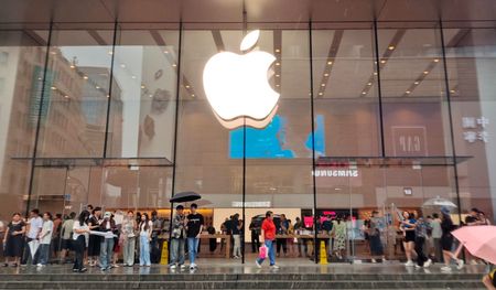 Customers brave the rain to inquire about exchanging their old iPhones for new ones at Apple's flagship Nanjing Road Pedestrian Street store in Shanghai, China, on September 10, 2024. 