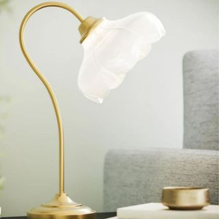 A gold and glass table lamp with engraved details