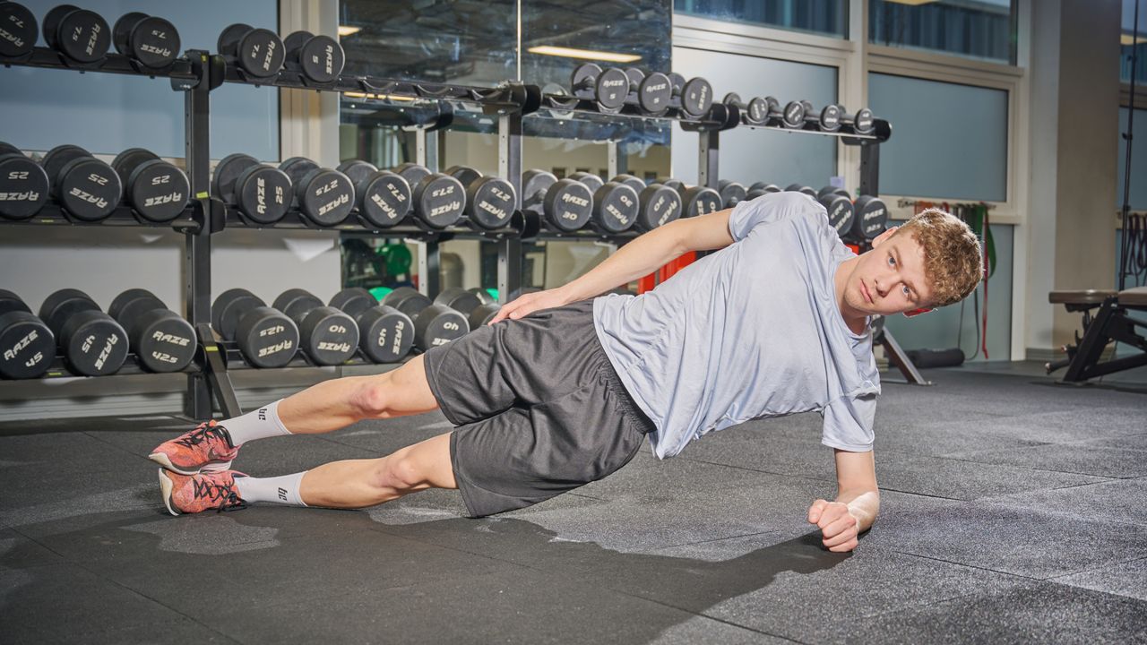 Male cyclist holding a side plank position as part of a bone health boosting routine