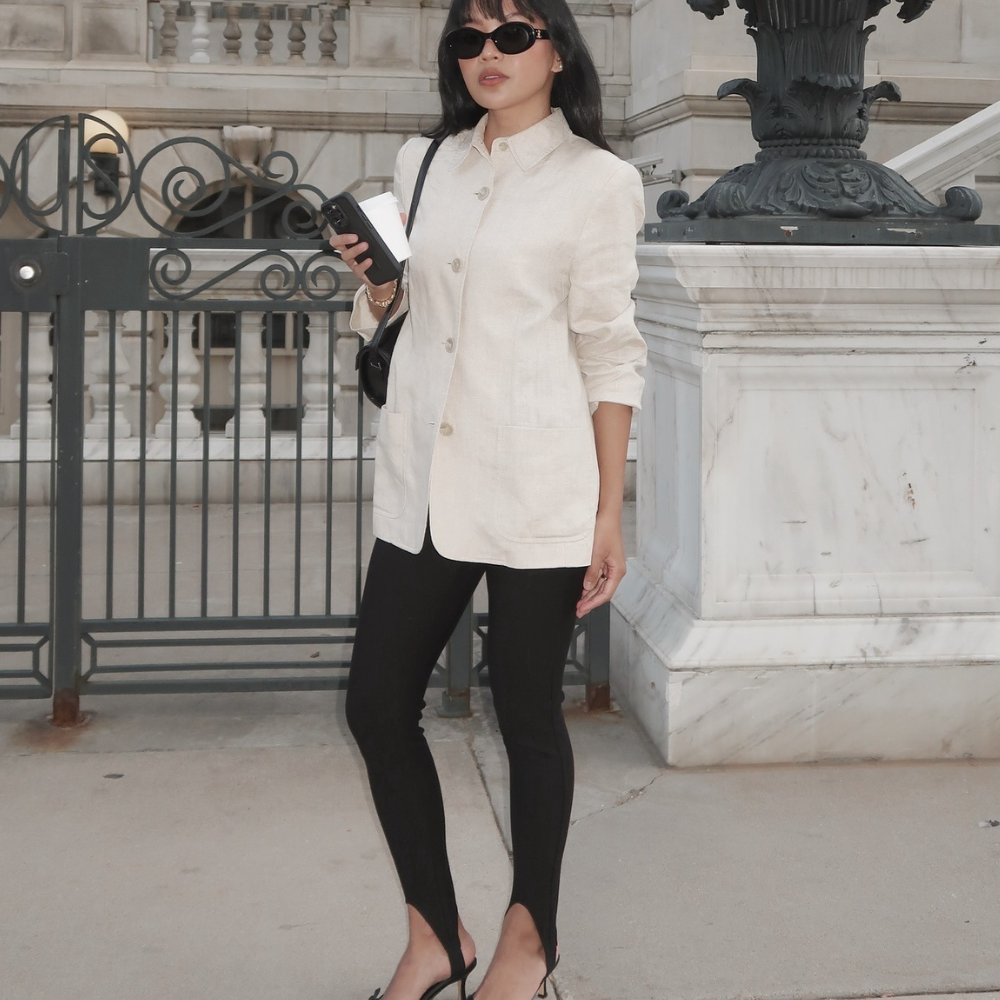 Fashion person Dawn Tan wears a winter legging trend. She wears a cream blazer, stirrup leggings and black bow kitten heels. This image was recently taken from her Instagram.