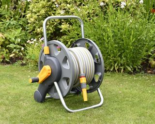 Hozelock 2 in 1 Compact Reel including 25m Hose pipe, nozzle and connectors lifestyle image on grass