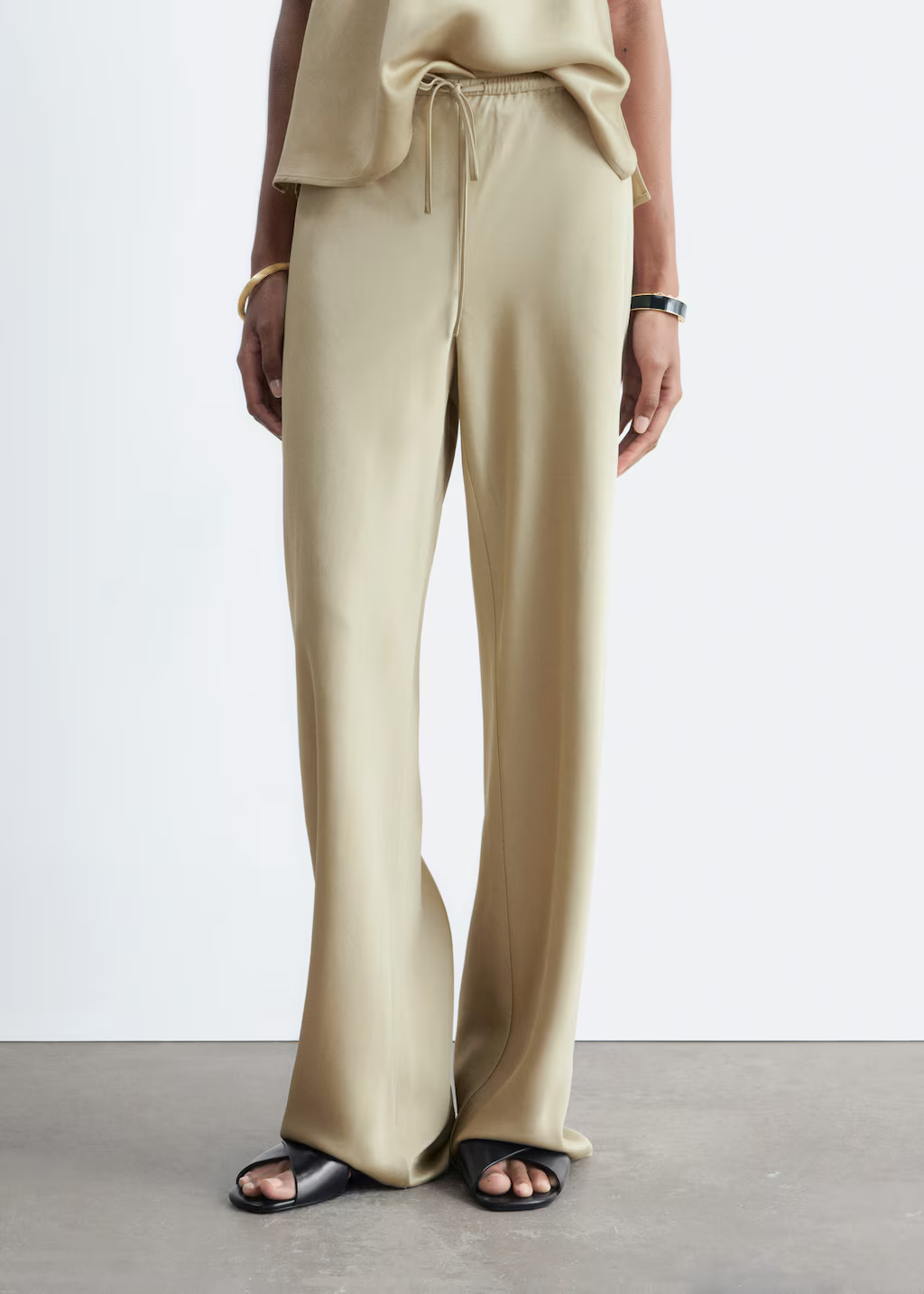 A model wearing a pair of beige &amp; Other Stories satin trousers