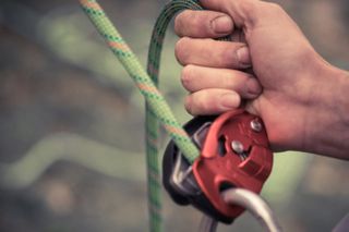 types of belay device: assisted belay device being used