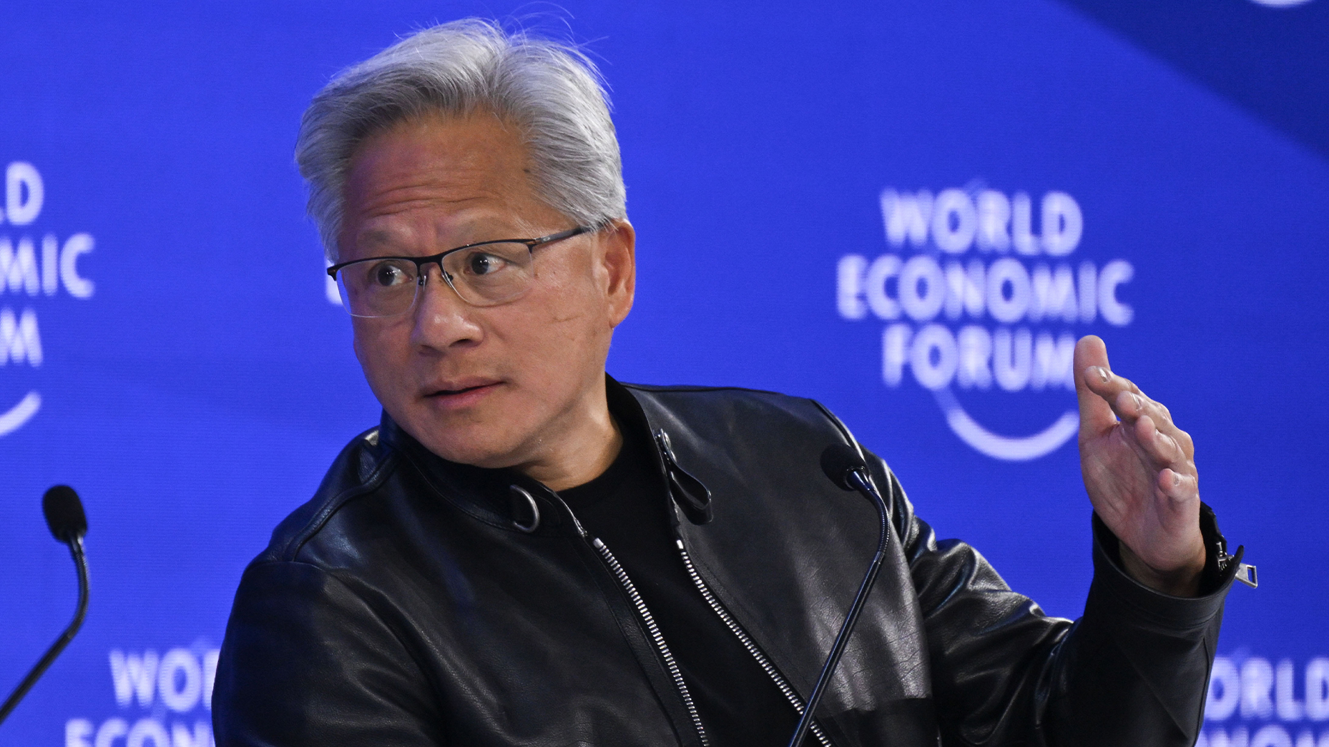 Nvidia CEO Jensen Huang pictured in conversation with BlackRock CEO Larry Fink at the 2026 World Economic Forum (WEF) in Davos while wearing a black leather jacket.